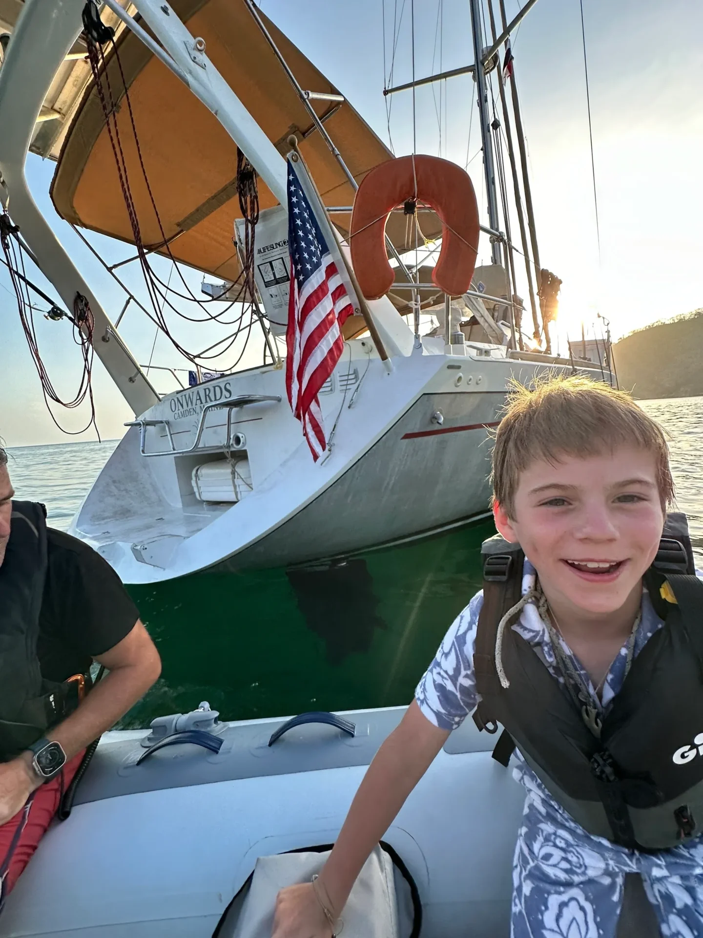 A man and boy in life jackets on a boat.