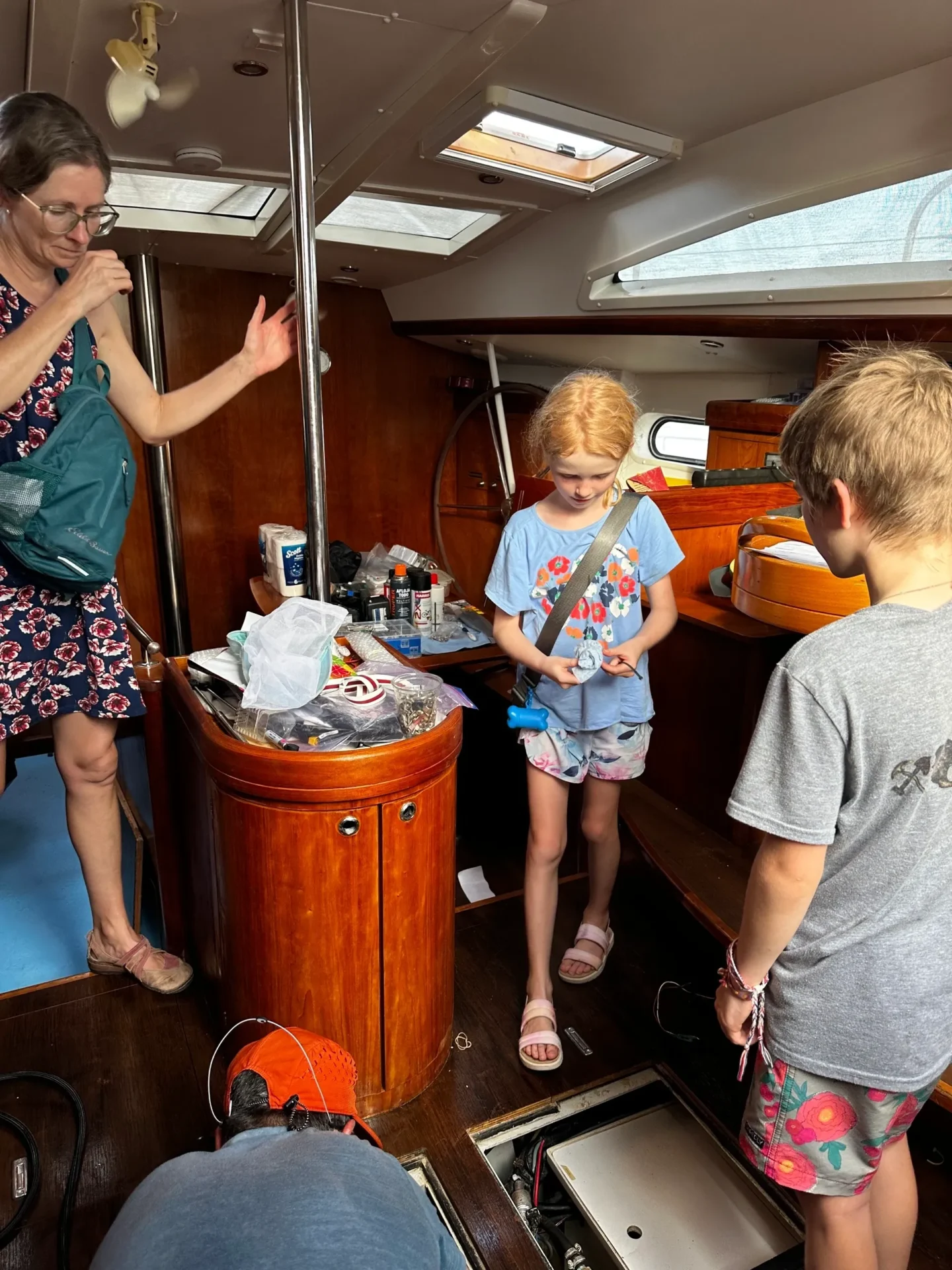 A woman and two children standing on the deck of a boat.