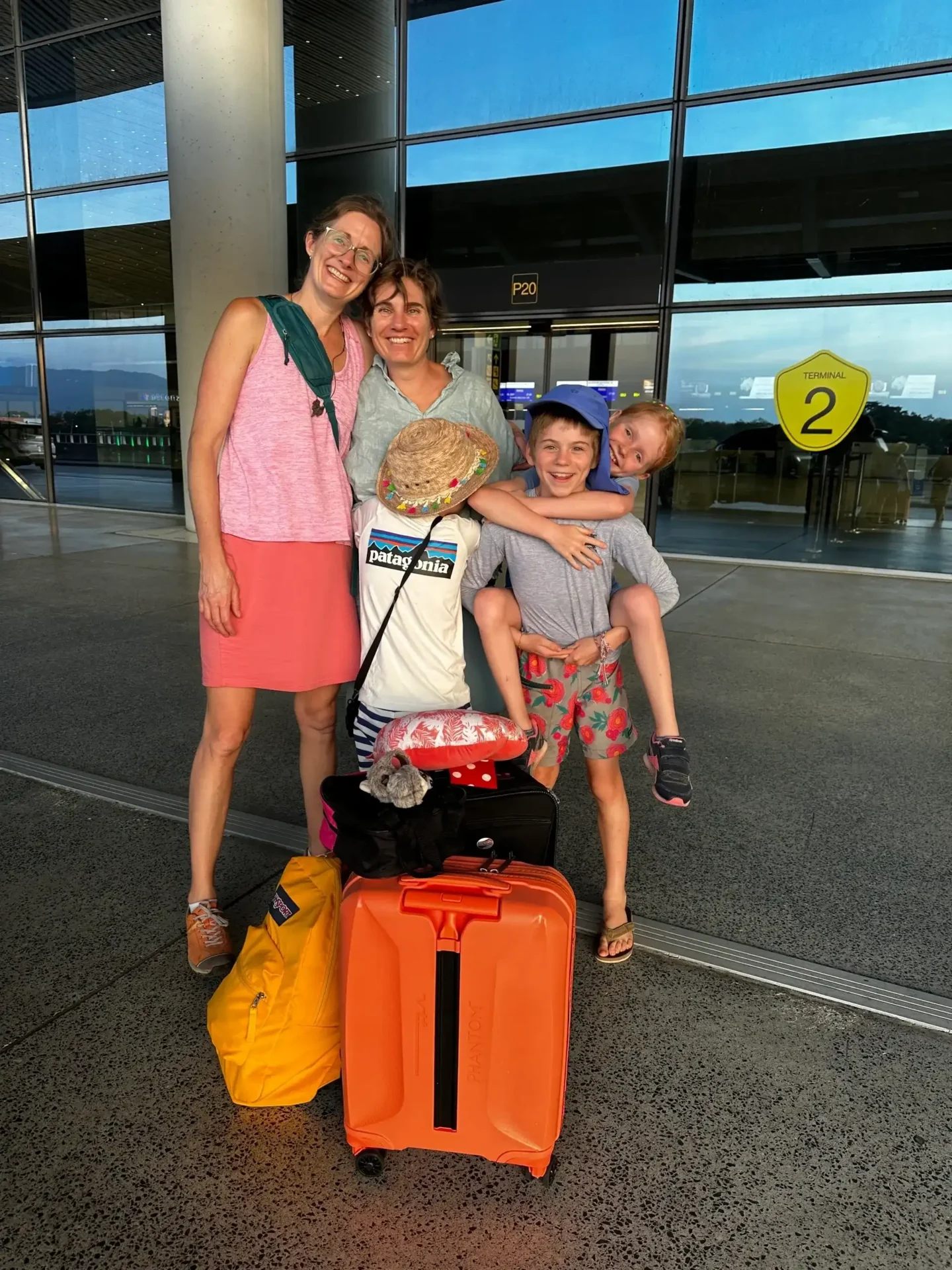 A family poses with their luggage at the airport.