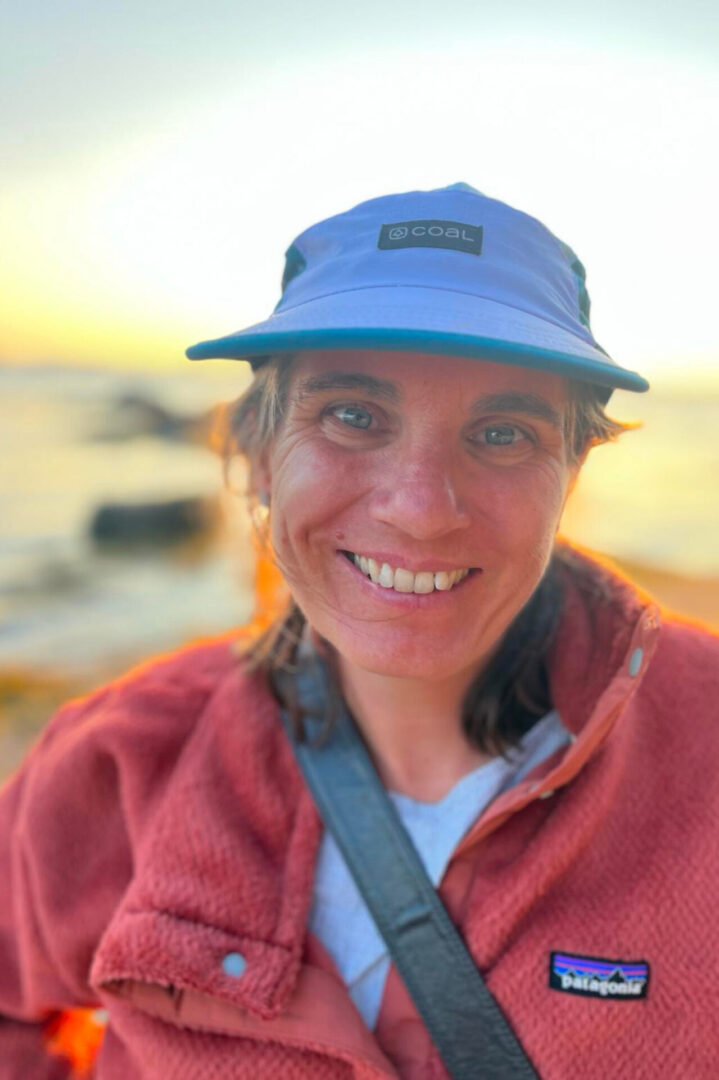 A woman wearing a hat and smiling for the camera.