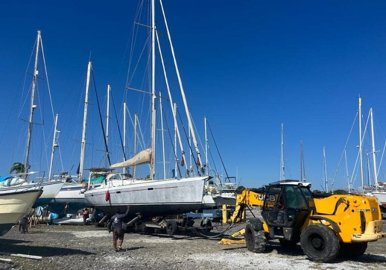 A man standing next to a boat in the water.